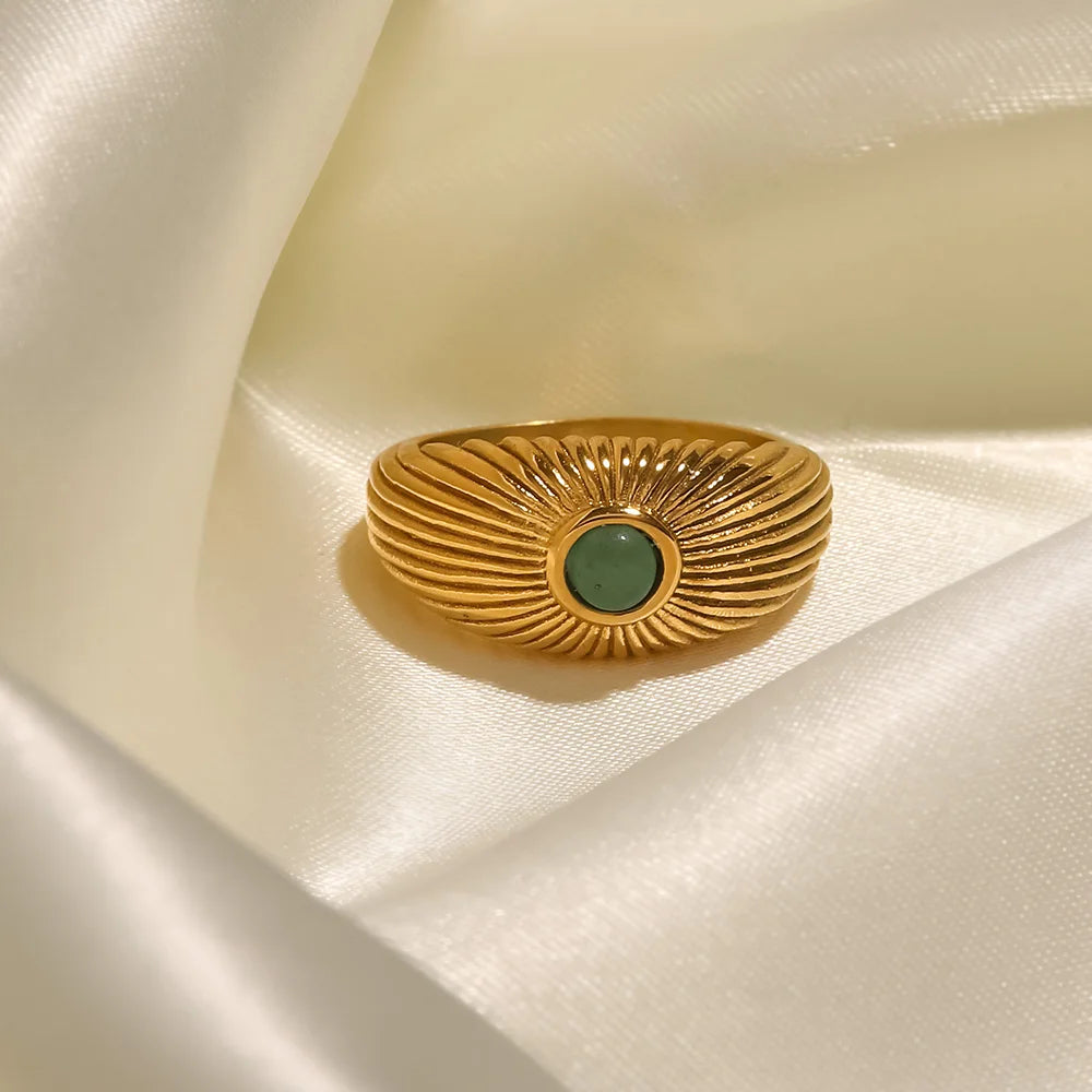 Green Stone Geometric Wrap Ring on satin fabric, featuring a vibrant green stone in a golden setting.