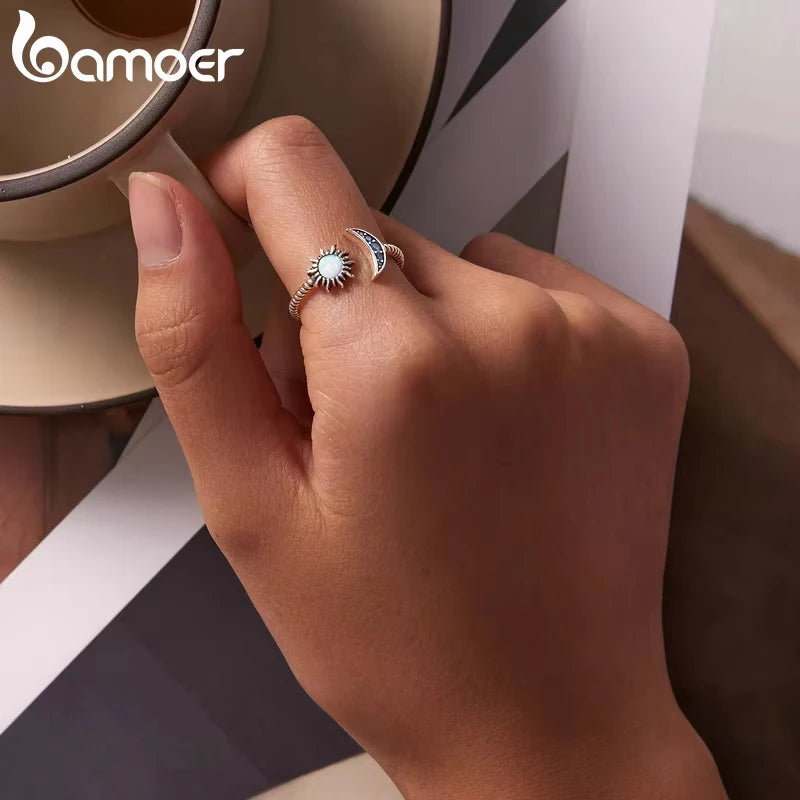 Authentic Silver Sun Moon Ring worn on hand with a cup, showcasing celestial design and elegant craftsmanship.