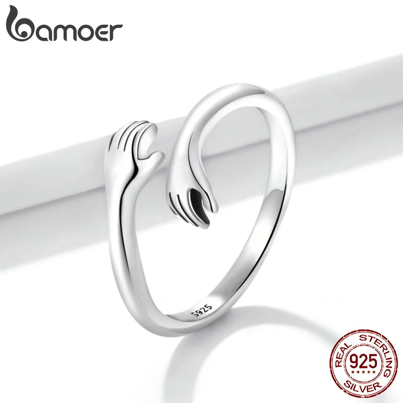 Sterling Silver Warmth Adjustable Ring showcasing a unique hand-hug design symbolizing care and affection.