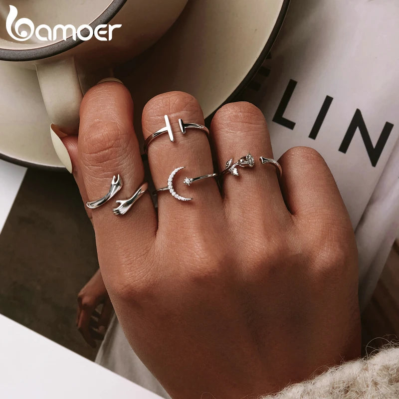 Sterling Silver Warmth Adjustable Ring worn among other delicate silver rings, highlighting its elegant design.