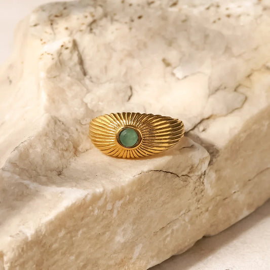 Green Stone Geometric Wrap Ring displayed on a natural stone background, showcasing modern elegance and vibrant green stone.